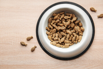 A bowl of dog food on a wooden floor.