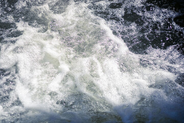 Fototapeta na wymiar stream of foaming cool water horizontal photo of a mountain stream or urban reservoir current