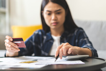 Business financial concept, stressed asian young woman hand checking list statement of credit card for calculate accounting expense, tax for payment on due deadline, trying to find money to pay debt