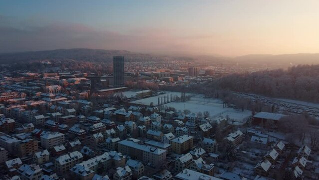 Warm sunset in winter over the city of Winterthur. Aerial view  flying towards the city center with Sulzer Hochhaus.