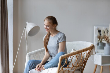 Dreamy happy woman sitting in a chair
