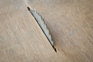 sharp metal saw on wood plank texture background, construction machine