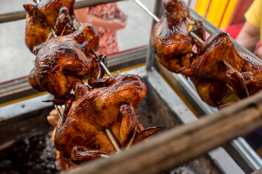 Lechon manok, a Filipino spit-roasted chicken dish. As seen being cooked in an oven at a roadside restaurant.