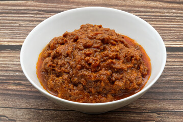 Ragù alla Bolognese on wooden table. Traditional Italian cuisine.