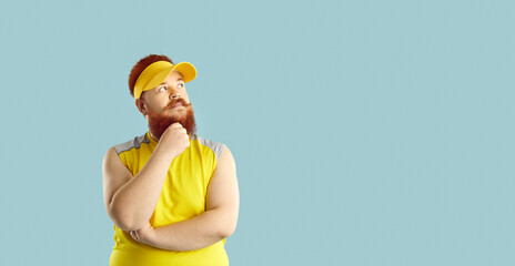 Fat sportsman standing isolated on blue background, holding hand on chin, looking at copy space on the right and thinking. Chubby man questioning his weight loss workout and fitness training program