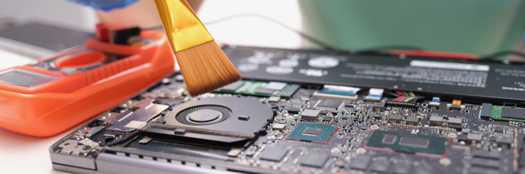 Maintenance laptop engineer holding dust brush closeup