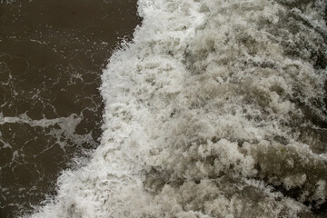 Strong foamy sea wave on the shore.