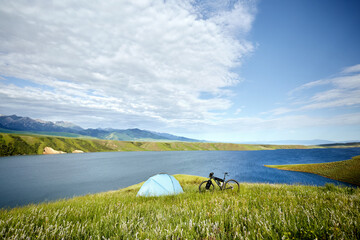 Mountain bike near tent near beautiful lake