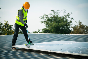 Maintenance technician using high pressure water to clean the solar panels that are dirty with dust to improve the efficiency of solar energy storage.