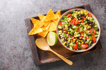 Cowboy caviar or Texas salad made with beans, corn, bell peppers, and tomato in chili lime vinaigrette for a delicious party appetizer closeup in the bowl on the table. Horizontal top view from above - obrazy, fototapety, plakaty
