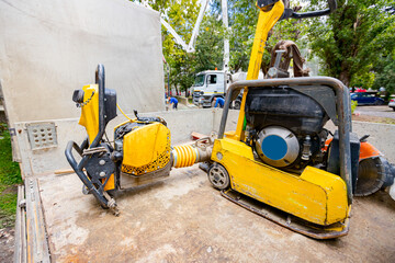 Used small yellow rammer standing soil compactor and compacting jumping jack machine at building...