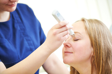 doctor measure eye pressure from female patient