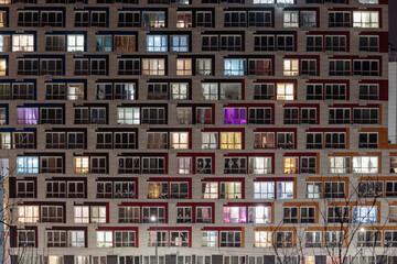 View of living apartment building windows at night.