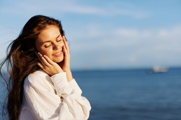 Woman beauty smile with teeth freedom on vacation walking on the beach by the ocean in Bali sunset, happy travel and vacation, sunset light, flying hair, skin and hair care concept in the sun
