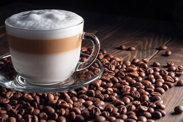 Close-up view of cup of hot coffee latte on a wooden table.