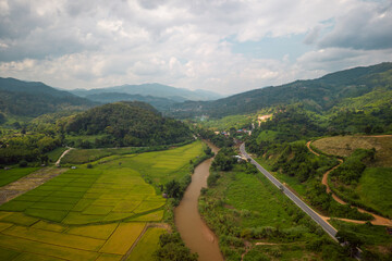 Aerial view of drone flying above village and rice field - 571806970