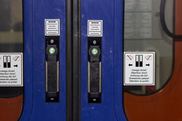 Door of train carriage or subway car with the electric green button press to open doors between the passenger wagons.