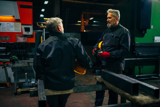 Joyful coworkers talking in workshop.