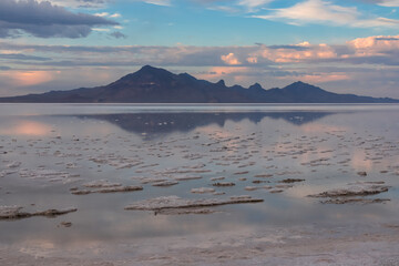 Scenic view of beautiful mountains reflecting in lake of Bonneville Salt Flats at sunset, Wendover, Western Utah, USA, America. Looking at summits of Silver Island Mountain range. Romantic atmosphere