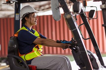 Indian woman staff worker work forklift driver at port cargo warehouse container yard for logistics industry happy smile © Quality Stock Arts