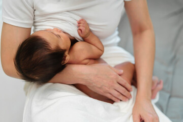 Obraz na płótnie Canvas close up mother breastfeeding newborm baby on bed