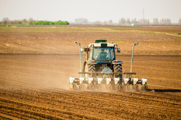 Obraz premium Farmer sowing soybean seeds in a field with modern equipment