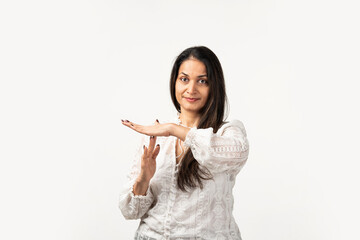 Indian mid age serious woman showing a time out gesture with hands, isolated white background