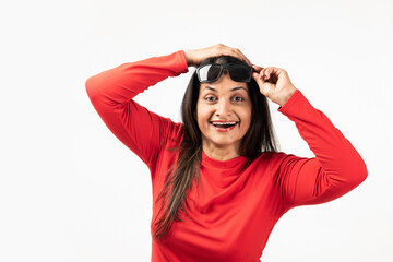 Mid aged Indian woman with wide open eyes and mouth, holding her specs, dark glasses with fingers