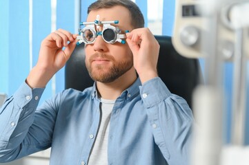 Handsome young man is checking the eye vision in modern ophthalmology clinic. Patient in ophthalmology clinic