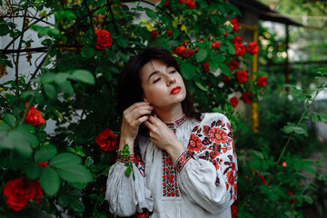 A girl in a national dress on a background of red flowers