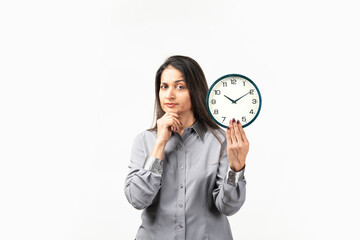 Mid aged&nbsp;Indian woman holding a clock isolated on white, confused, feels doubtful and unsure.