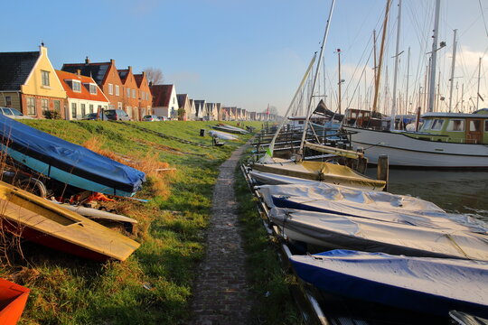 The village of Durgerdam, North Holland, Netherlands, located near Amsterdam along the dyke of the IJmeer (IJ lake), with colorful wooden houses and boats. Picture taken in winter after sunrise.