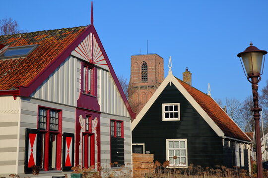 Colorful and traditional wooden houses in the village of Ransdorp, North Holland, Netherlands, located near Amsterdam, with the Kerk van Ransdorp (church of Ransdorp) in the background