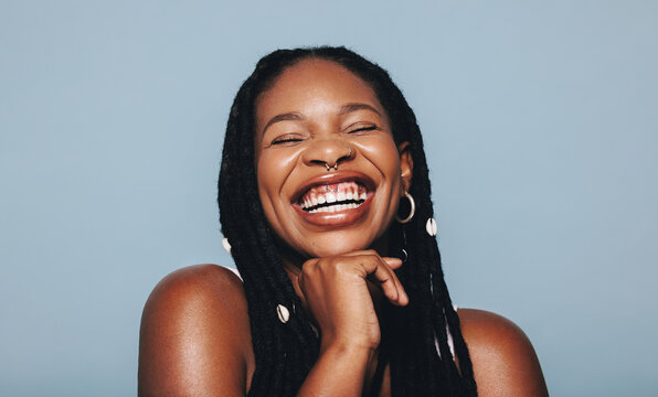 African woman with face piercings smiling cheerfully in a studio