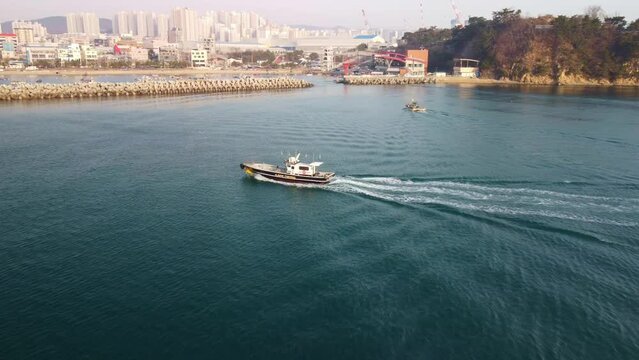 Drone aerial view of a fishing boat returning to the Ilsan port near Daewangam, Ulsan district, South Korea.