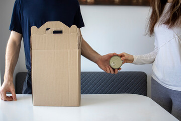 Two volunteers fill the box with canned goods and food. The donation box.