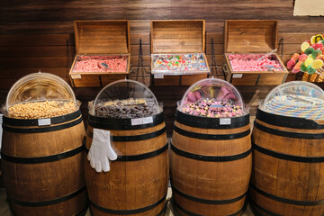 Multicolored gummy candies and marshmallows jelly, caramel sold in store wooden barrels chests