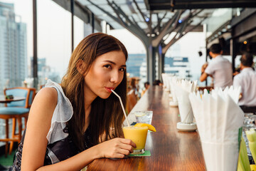 Asian Woman Drinks Cocktail