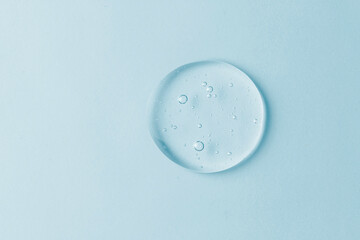 Cosmetic lotion transparent gel drop texture, on blue background