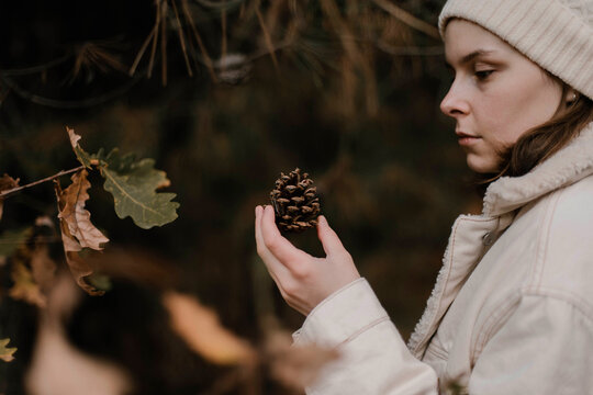 A woman hold a pinecone in her hand - Powered by Adobe