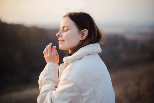 Portrait of a beautiful young woman in warm clothes during sunset