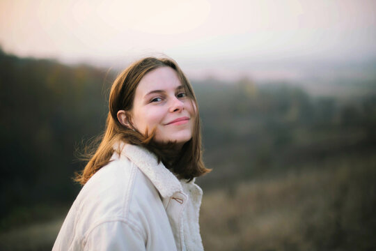 Portrait of a beautiful young woman in warm clothes during sunset