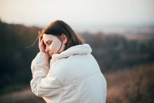 Portrait of a beautiful young woman in warm clothes during sunset