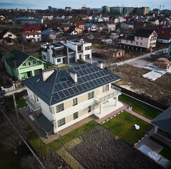 Aerial view of two-storey house with solar panel modules for generating electricity through...
