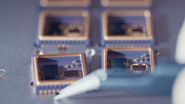 Macro shot of wire bonder connecting wires to a microchip at high speed
