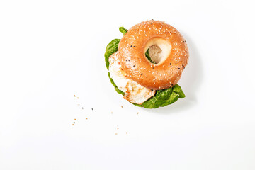 Fresh bagel with egg and salad on a white background. Breakfast concept with space for text