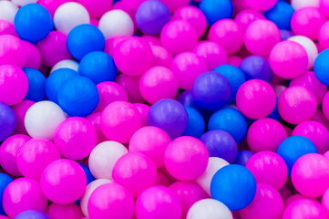 Background, closeup texture of colored, multi-colored round plastic small balls on the playground for children's games. Photo, top view, copy space.