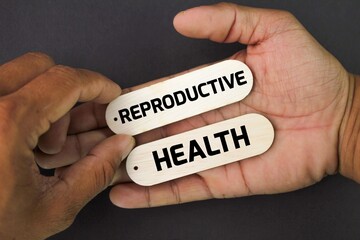 hand holding a stick with the word Reproductive Health