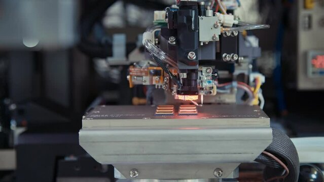 Macro shot of wire bonder connecting wires to a microchip at high speed