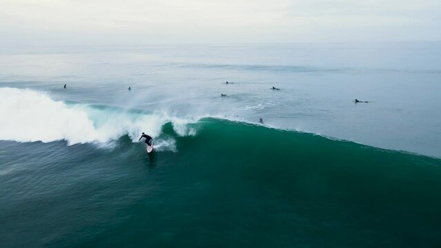Aerial view of an unrecognizable surfer catching a wave in Carlsbad